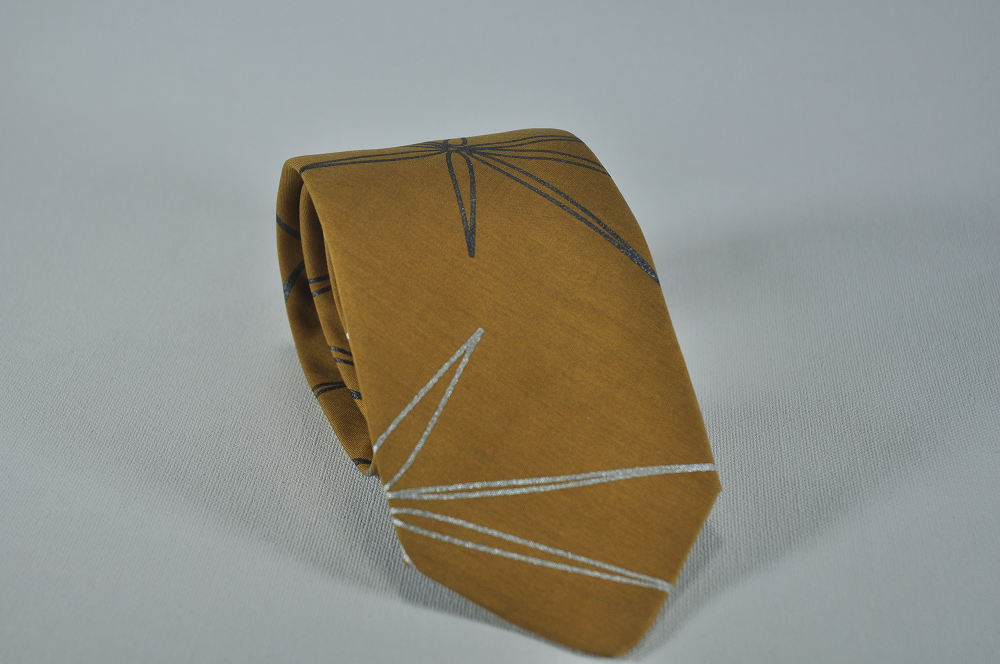 toffee colored tie with silver and pearlescent black stars printed on the surface.